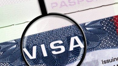 Magnifying glass highlighting 'VISA' on a passport.